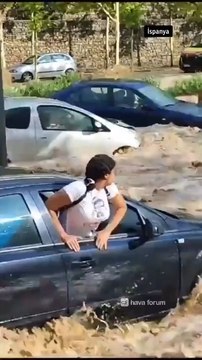 Inondations en Espagneles gens s’accrochent au toit de leurs voitures pour sauver leur vie alors qu'elles sont emportées.