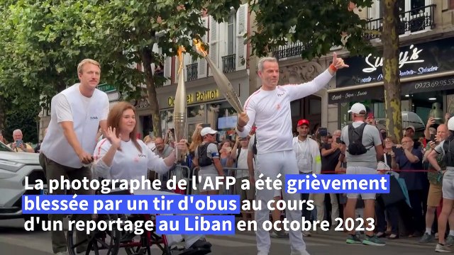 Les journalistes de l'AFP Christina Assi et Dylan Collins portent la flamme olympique