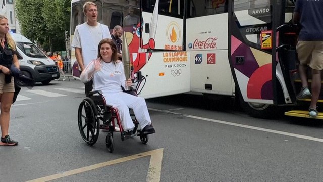 Les journalistes de l'AFP Christina Assi et Dylan Collins portent la flamme olympique