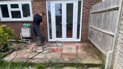 Pressure washing an overgrown patio reveals its true beauty