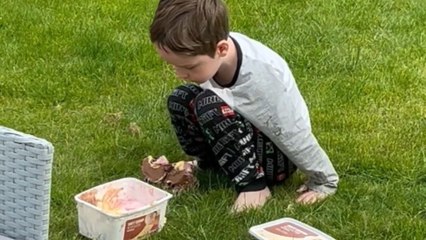 Little boy sneaks ice cream outside while dad is unaware
