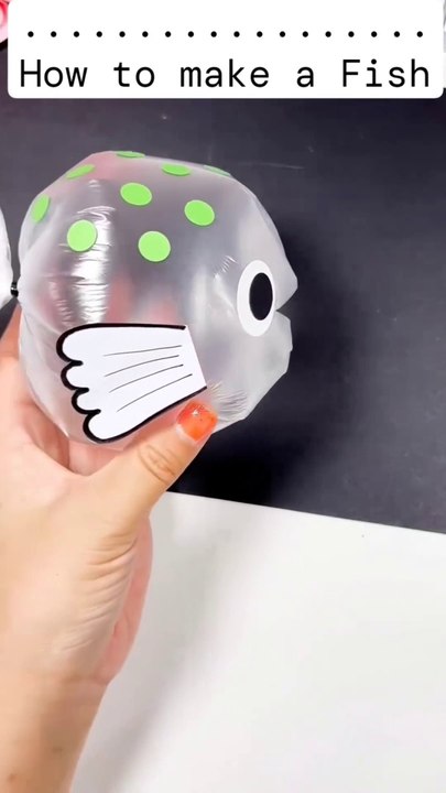 Watch as I transform a simple plastic bag into an adorable fish! Start by sealing the bag with a hair band...Inflate the bag with air and seal it again. Cut out and attach fins and eyes to give it character. In just a few easy step