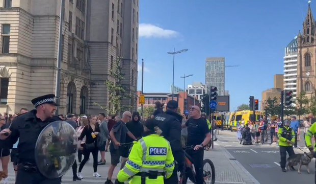 Riot police with police dogs stand against far-right protestors in Liverpool