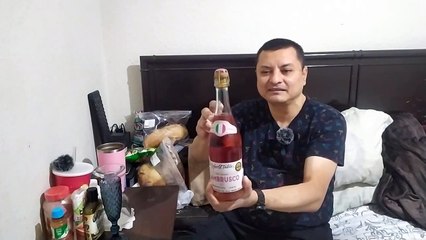 Abriendo una botella de vino rosa lambrusco  para beber en una noche con calor de verano delicioso