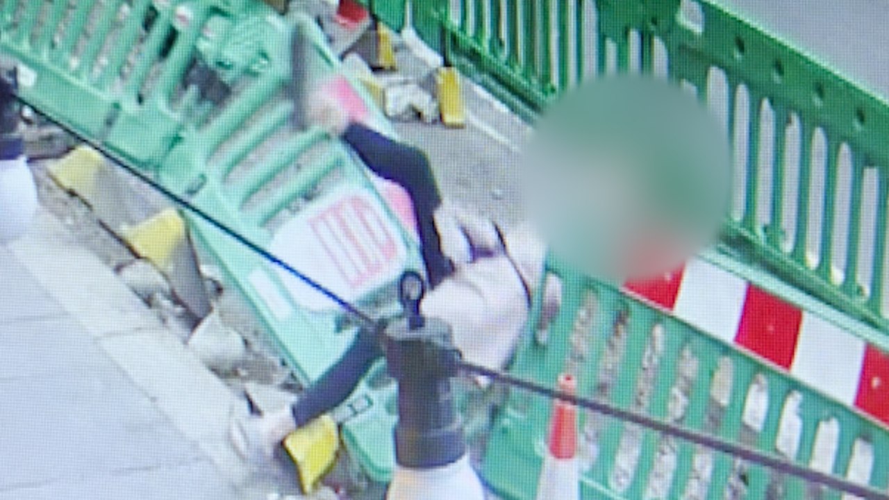 Moment, in dem eine Frau eine Bar verlässt - und geradewegs in einen Gully fällt
