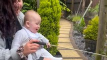 Joyful family time: Baby laughs as cat plays with its favorite toy