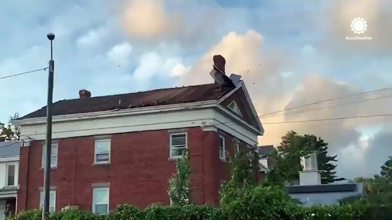 Debris flies off from damaged roof during windy day in Vermont