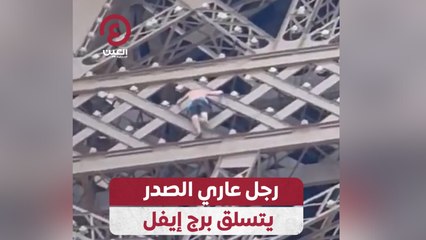 رجل عاري الصدر يتسلق برج إيفل