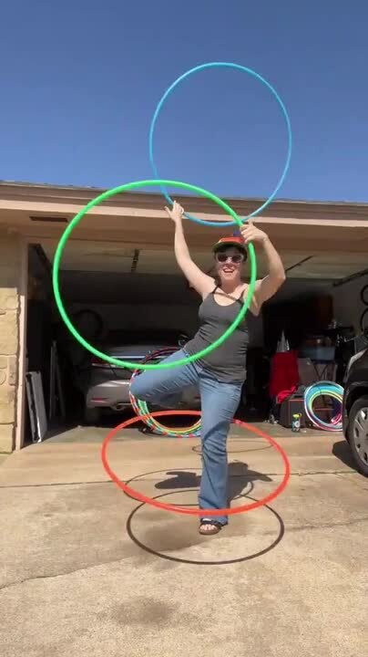 Circus Artist Shows Multiple Tricks Using Three Hula Hoops