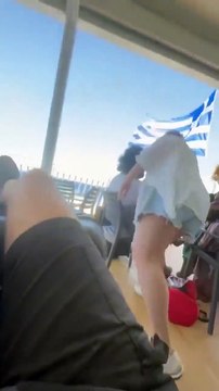 Elle balance l'enceinte de touriste par dessus bord sur un bateau de croisiere