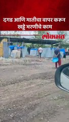 दगड आणि मातीचा वापर करून  खड्डे भरणीचे काम