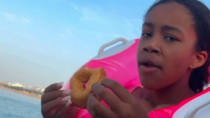Beach day twist: Seagull swoops in and snatches doughnut from the girl's hand
