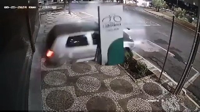 Condutor perde o controle na Praça da Bíblia, sobe na calçada, destrói placa e tomba carro