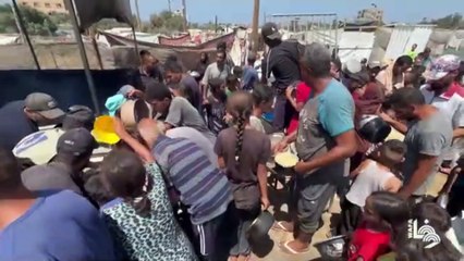 Savaşın harap ettiği Gazze'deki mülteci kampında Filistinli çocuklar yemek için sıraya giriyor