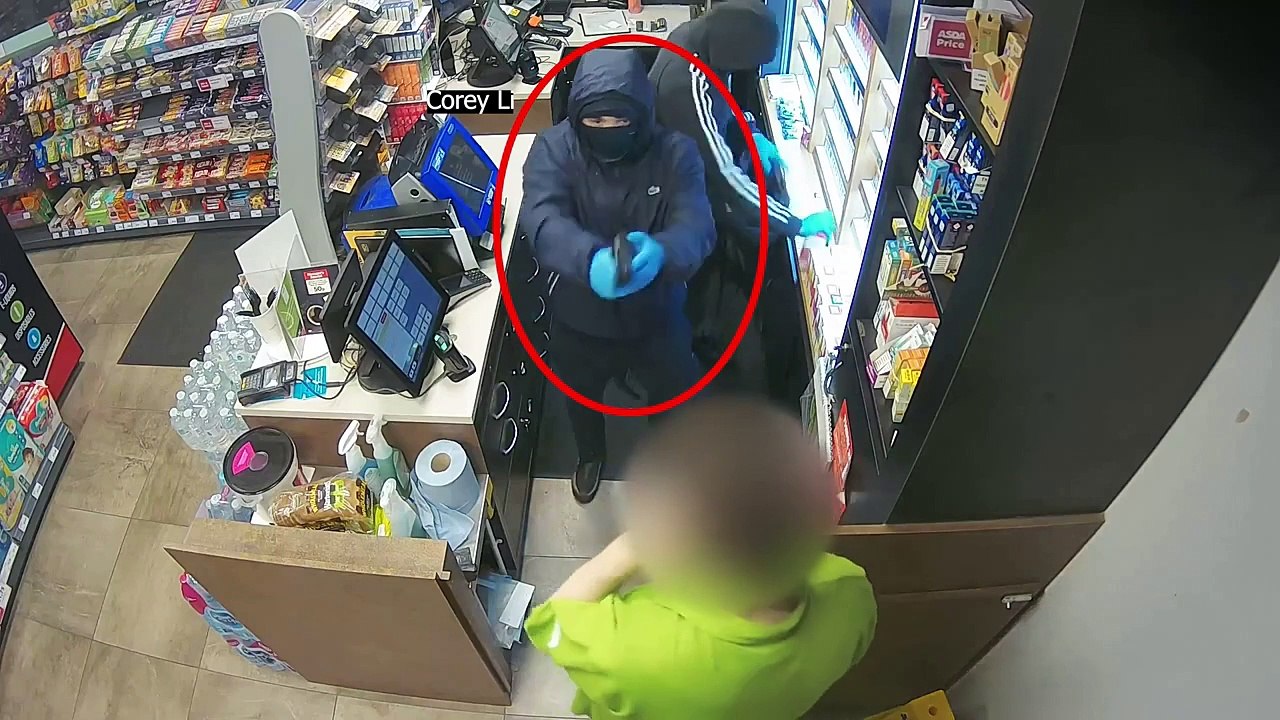 Masked robber shoves imitation gun in 'stoic' shop worker's face in terrifying raid