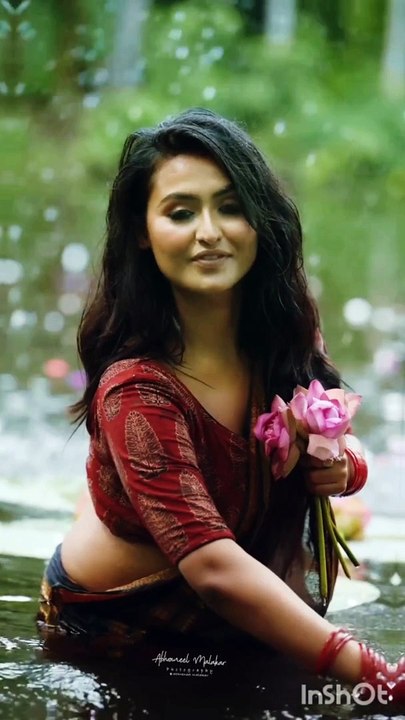 Hot Indian Bengali girl in wet saree collecting flowers