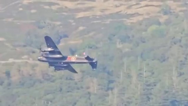 Second World War-era Avro Lancaster Bomber flies over lake