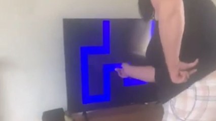 Mom screams after a scary face suddenly pops up on the TV screen