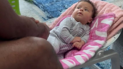 Dad gently taps baby to sleep but baby isn't in the mood yet