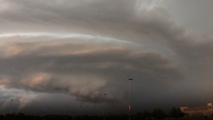 A massive storm cloud and a peaceful sunset meet in a mesmerizing time-lapse in Norman, Oklahoma.