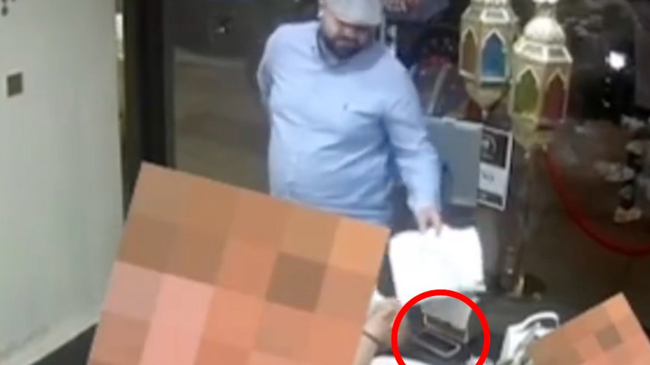 Moment, in dem ein dreister 'dieb’ gäste mit papier ablenkt, während er 'handy stiehlt’