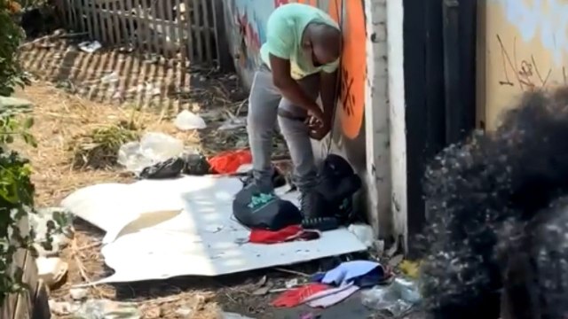 Easy-going man turns his jeans into shorts to combat the heat during Notting Hill Carnival