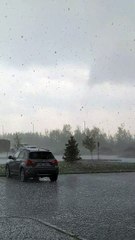 Person is filming a loud hailstorm and looking toward parked cars!