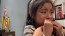 Little girl says goodbye to her loose tooth with a touch of sisterly love