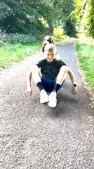 Dog Pushes Boy on Skateboard Along Path