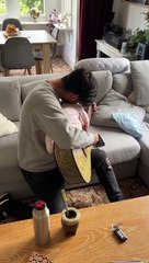 Dad puts his daughter to sleep on top of his guitar while he's playing!