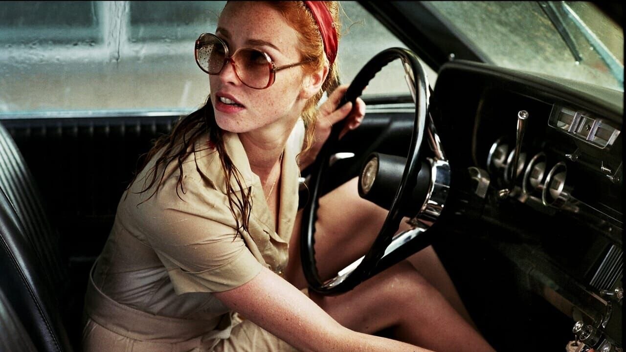 La dame dans l'auto avec des lunettes et un fusil