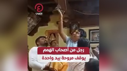 رجل من أصحاب الهمم يوقف مروحة بيد واحدة