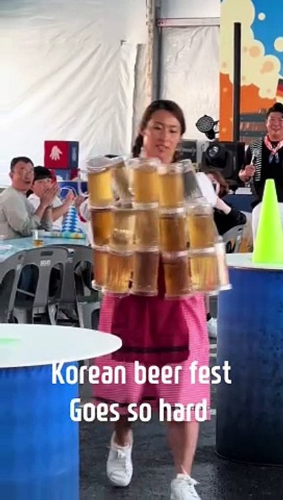 Un mujer intenta participar en un concurso de cargar jarras de cerveza de Oktoberfest en Corea del Sur