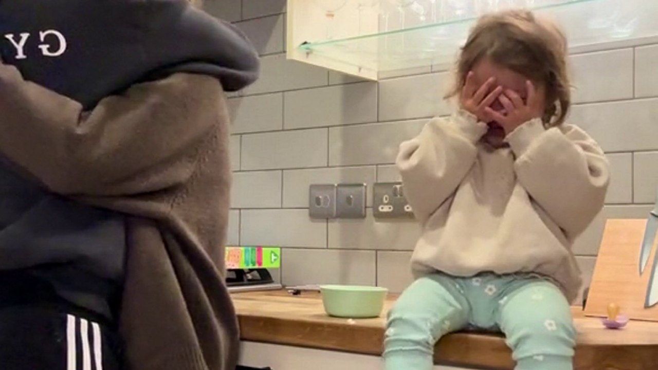 Freches Kind auf Kamera gefangen, vorgibt zu weinen, um eine Umarmung von Dad zu nehmen