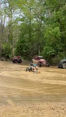 Kid is doing water wheelies in a water hole at an ATV park!