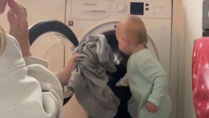 Little girl lends a hand as she helps mom wash clothes