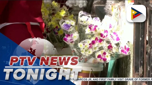 Flower, candle vendors selling their items to visitors while hiding behind a wall inside Manila North Cemetery