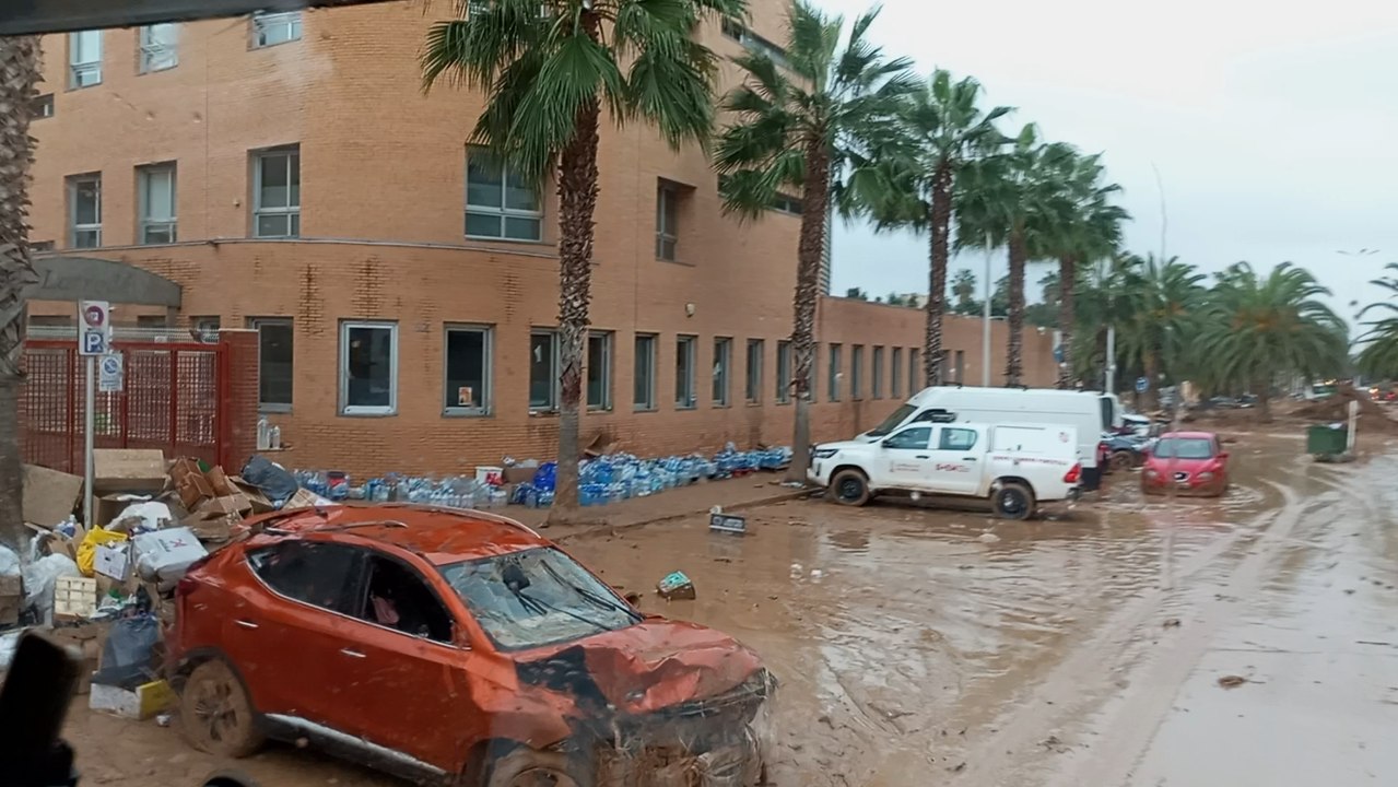Decenas y decenas de botellas de agua, este domingo, acumuladas sin custodia alguna, en una acera del Colegio Larrodé de Catarroja.