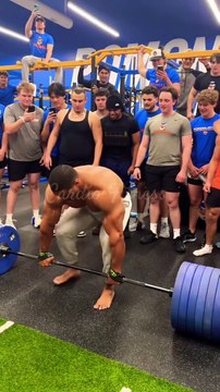 A weightlifter in the gym lifting heavy dumbbells.