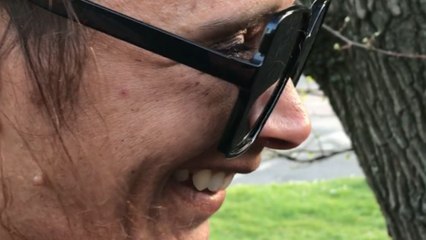 Man pushes dandelion into his wife’s mouth as she prepares to blow it