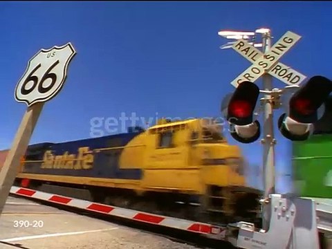 Low angle PAN freight train passing train crossing on Route 66 : Southwestern US - stock video