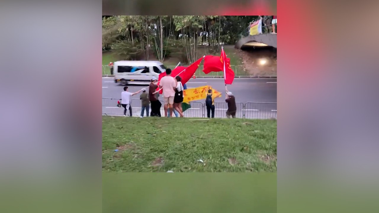 Bayrak taşıyan Çinliler, Brezilyalı protestocuların önünü kapadı