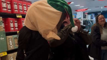 Girl sneaks up on her aunt with the elf mask during Christmas shopping