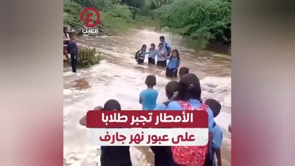 الأمطار تجبر طلابا على عبور نهر جارف