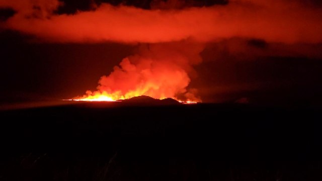 Blazing lava illuminates the serene night sky during volcano eruption on Reykjanes Peninsula