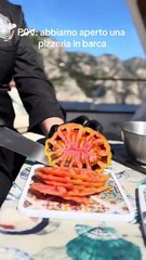 Chef prepares a beautiful pizza on a boat and gives it to people on another boat!
