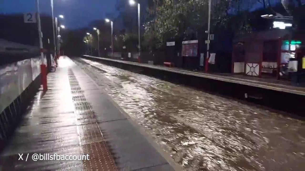 Floodwaters gush down tracks of Walsden Station