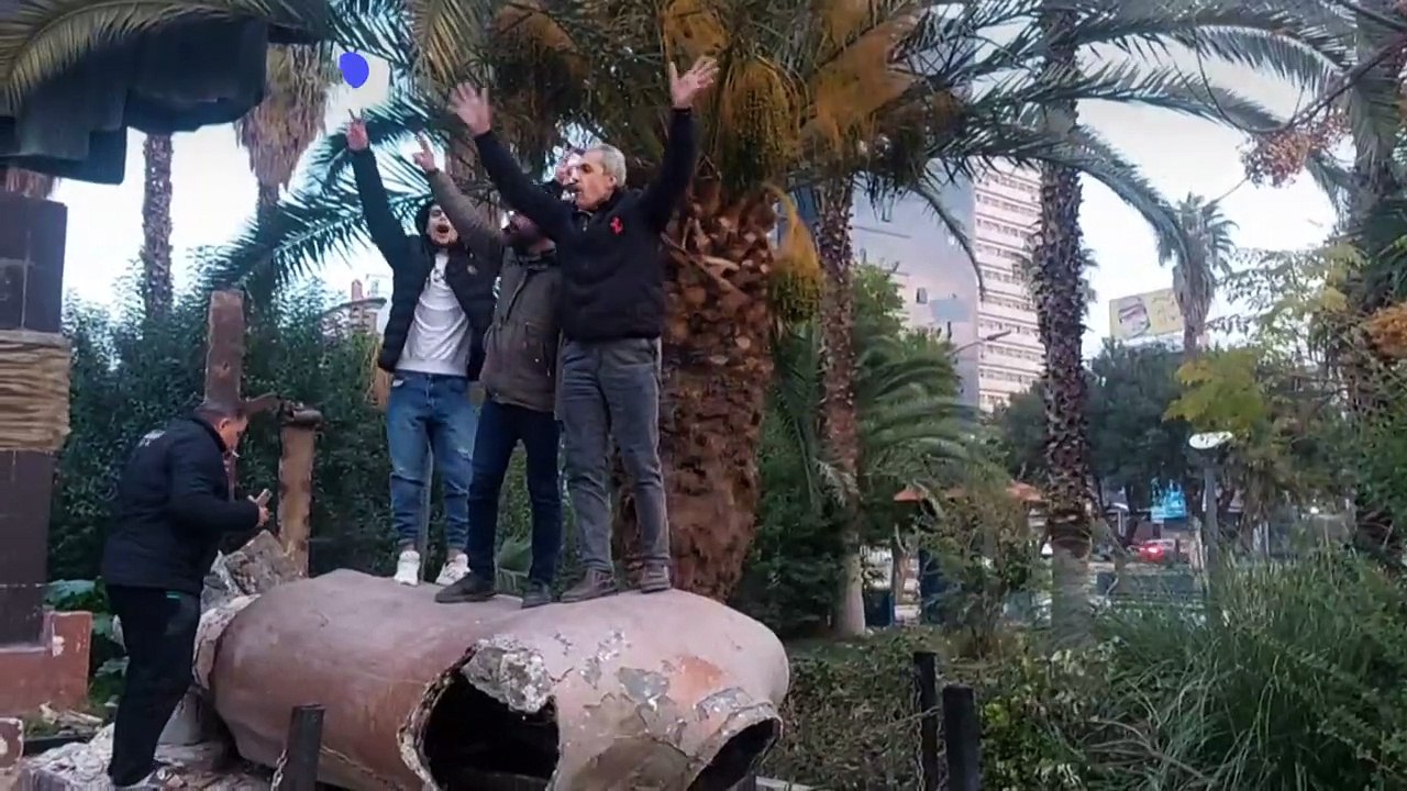 سوريون يشوهون تمثالا للرئيس الراحل حافظ الأسد في وسط دمشق