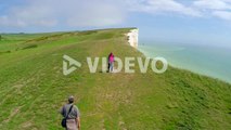 Aerial shot of people walking along the White Cliffs of Dover at Beachy Head England