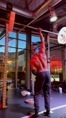Man is doing a one arm back-lever while holding a 30kg barbell!
